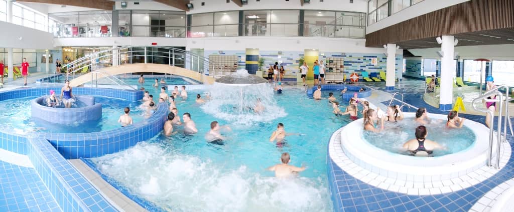 Zdjęcie przedstawia basen rekreacyjny z osobami w wodzie